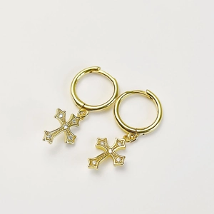 Detailed macro of gold hoop earrings with vintage-style cross pendants set with zircons