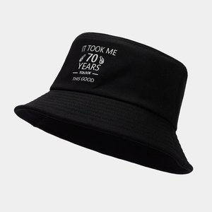 Detailed view of 70th birthday bucket hat with funny slogan on black cotton fabric