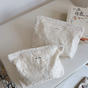 Flat lay of cream cotton pouches with floral embroidery and simple wish brand labels