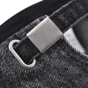 Detail of adjustable metal buckle and dark grey washed denim texture on baseball cap