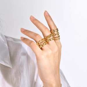 Detail of 18k gold plated stainless steel chain rings worn on woman's fingers