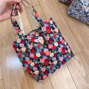 Detail shot of vibrant floral cotton handbag with zip closure and simple wish woven label