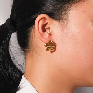 Polished 18K gold-plated titanium steel hollow flower stud earrings worn by model