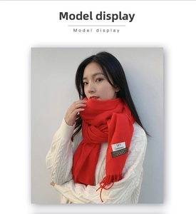 Close-up of bright red cashmere wool scarf with soft tassel details and fabric label