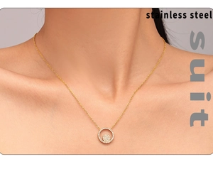 Détail d'un collier en acier inoxydable doré avec un pendentif rond serti de zircon blanc