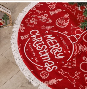 Detail of red Christmas tree skirt with white tassels and holiday pattern printing