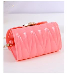 Detail of pink jelly mini bag featuring quilted texture and gold metal chain strap