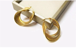 Detail view of 18K gold plated multi-layer wave spiral hoop earrings on a display case