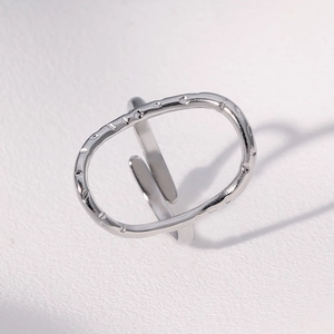 Macro side view of silver stainless steel ring with hammered oval hollow design