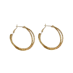 Chic twisted golden double hoop earrings with textured finish in minimalist metal style