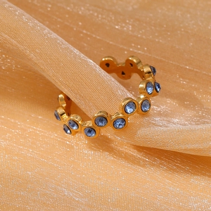 18k gold plated stainless steel open ring with round blue zircons on pink fabric