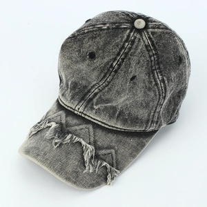 Detailed close-up of distressed brim with fringe on a washed denim baseball cap