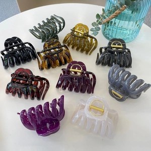 Flat lay of multiple colorful pumpkin hair claw clips on a clean white surface