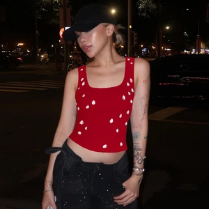 Detail of red slim fit crop top with white droplet embellishments in street style shot