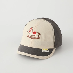Close-up of embroidered rocking horse and woven label on color-block kids baseball cap