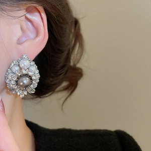 Close-up of a vintage crystal pearl drop earring worn by a model in warm lighting