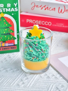 Detail of Christmas tree shaped soy candle in glass jar with colorful sugar beads