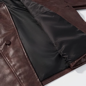 Gros plan sur la texture du cuir marron vintage avec doublure noire et coutures de précision