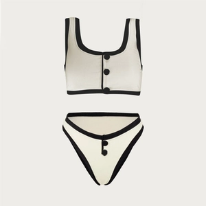 Minimalist black and white two-piece swimsuit with button accents and ribbed texture