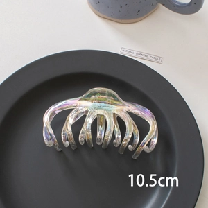 Detail shot of a 10.5cm holographic laser shark hair clip on a black minimalist tray