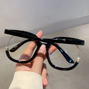 Detail of half-rim glasses featuring black frame and gold metal with rhinestone accents