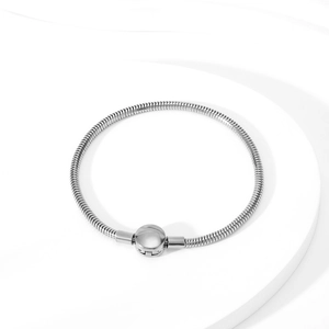 Detailed view of silver snake chain bracelet with round clasp on white stand