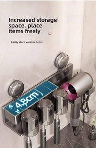 Macro detail of wall-mounted gray suction toothbrush holder with hair dryer stand