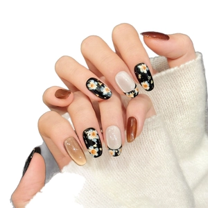 Handmade brown cat-eye and black floral press-on nails in elegant oval shape