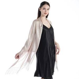 Close-up of light pink sparkling shawl with fringe details on a fashion model