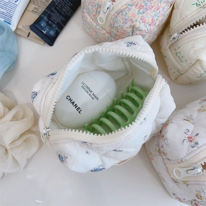Vue de dessus de trousses de maquillage matelassées à fleurs avec fermeture éclair