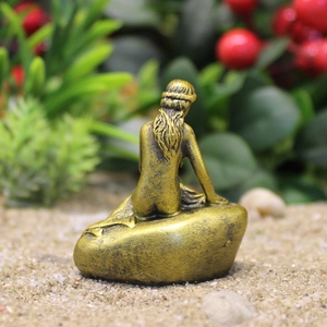Escultura artística de sirena con acabado en bronce sobre base de piedra decorativa