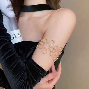 Detailed close-up of a gold hollow floral upper arm cuff bracelet on a model