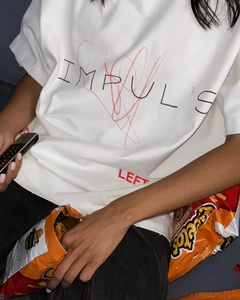 Détail d'un t-shirt blanc en coton avec graphique de cœur rouge et lettrage IMPULSE