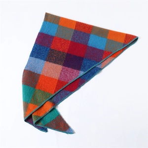 Detail of colorful patchwork plaid scarf with blue and red squares and stitched edges