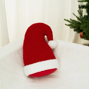 Coussin bonnet de Noël en peluche rouge et blanc sur une couverture douillette