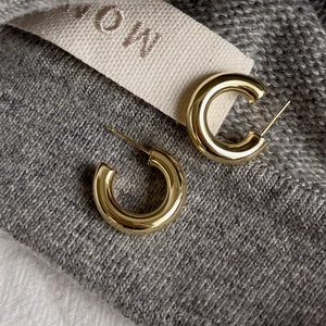 Minimalist 925 silver C-shape gold hoop earrings with polished finish on knit fabric