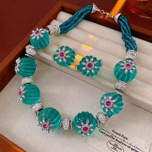 Detailed view of vintage floral jewelry set with turquoise beads in a wooden box