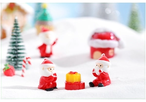 Macro shot of miniature Santa Claus figurines and gift box for Christmas micro landscape