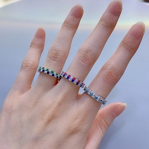 Close-up of stacked S925 silver rings with colorful zircon stones on female fingers