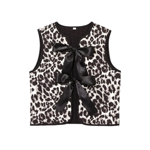 Detail of animal print quilted vest featuring two large black satin ribbon bows in front