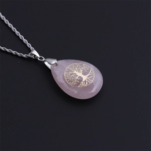 Collana con ciondolo a goccia in cristallo rosa con albero della vita dorato su sfondo nero