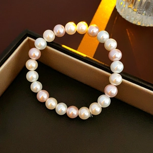 Macro detail of white and pink pearls on a bracelet inside a luxury brown jewelry box