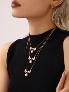 Détail d'un collier plaqué or 18 carats avec pendentif papillon rose et perle blanche