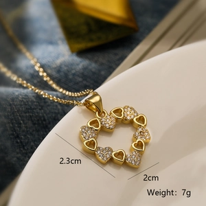 Macro shot of gold heart pendant with cubic zirconia inlay showing 2.3cm x 2cm dimensions