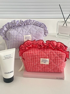 Detail of purple and red quilted berry-colored cosmetic bags with decorative ruffles