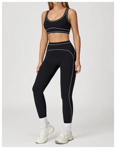 Close-up of black yoga set featuring white contrast stitching on sports bra and leggings