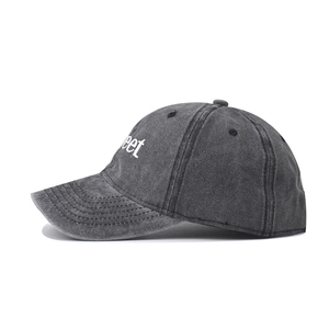 Detail of vintage washed cotton fabric and white 'sweet' embroidery on dark grey baseball cap