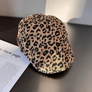 Detailed macro view showing the leopard print texture and thick wool fabric of the beret hat
