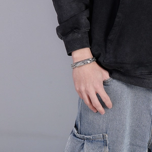 Detailed view of hip-hop feather cross titanium bracelet with vintage oxidized finish