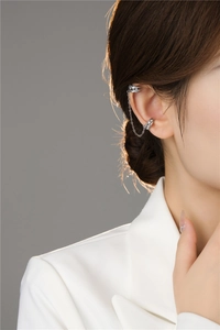 Close-up of a silver tassel ear cuff with fine metal chain on a model's ear